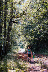 Obraz premium Mother with daughter walking through the forest