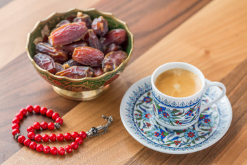 Turkish coffee, dates, and red rosary on table side view