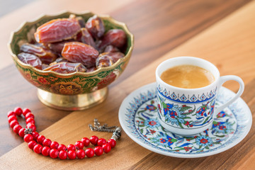 Turkish coffee, dates, and red rosary on table side view