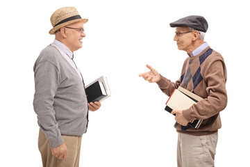 Two senior men holding books and talking