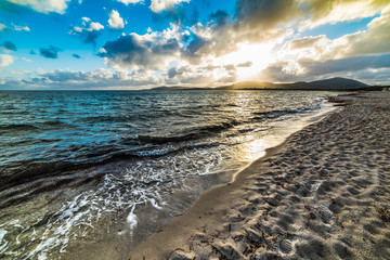 Sandy shore under a cloudy sky at sunset