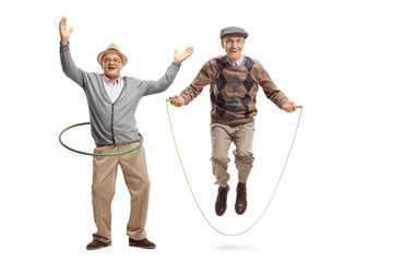 Cheerful mature man with a hula hoop and a senior man jumping on a skipping rope - obrazy, fototapety, plakaty