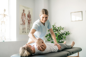 A Modern rehabilitation physiotherapy worker with woman client - obrazy, fototapety, plakaty