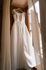 white wedding dress hanging on a hanger
