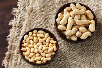 Peanuts in the shell and peeled closeup in a cup