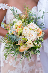 the bride is holding a rustic wedding bouquet of flowers and various herbs