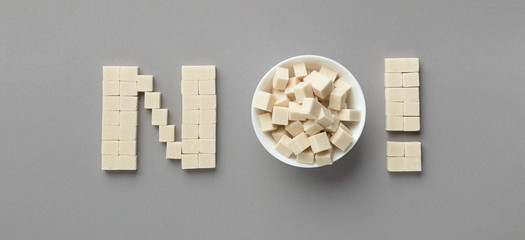Sugar cubes arranged as word NO panorama - Powered by Adobe