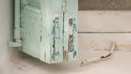 Weathered green and blue painted window-shutter in a window in the village Kapsali on the island Kythera, Greece