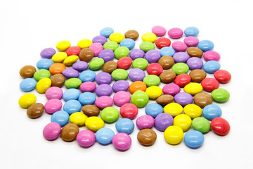 Bright multicolored glazed chocolate candies on white