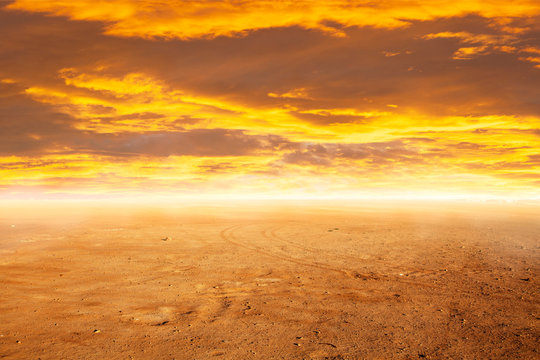 Desert sand under a sunset sky © George Dolgikh