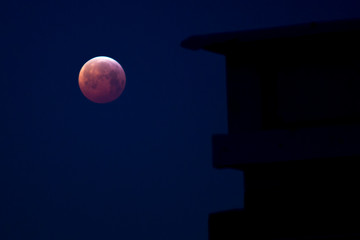 Lunar eclipse with silhouette of a building