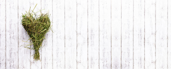 handmade nature heart as a sign of love on white wooden backdrop. beautiful green grass. 