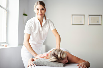 A Woman enjoying spa treatment at salon with masseur worker - obrazy, fototapety, plakaty