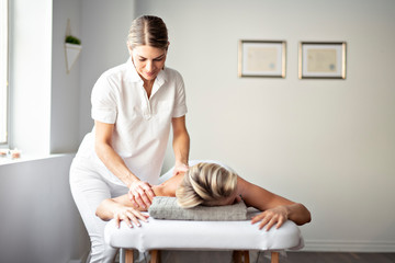 A Woman enjoying spa treatment at salon with masseur worker - obrazy, fototapety, plakaty