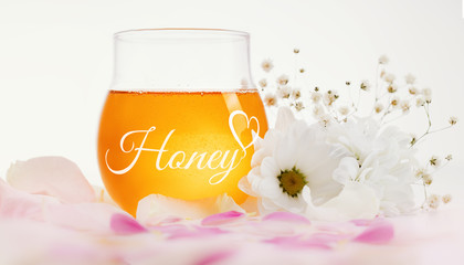 Honey and flowers on a wooden background