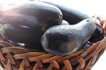 ripe eggplant in a wicker basket, close-up, isolated white background, top view. toned
