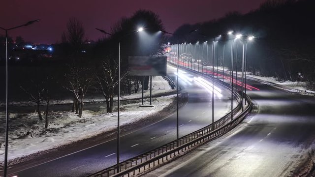 Fast moving traffic at night. Timelapse. winter season. concept of the road, snow and ice removal, danger and safety of movement, street lighting with energy-saving lamps