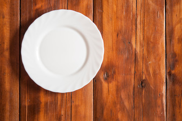 Blank white dish on a wood background.