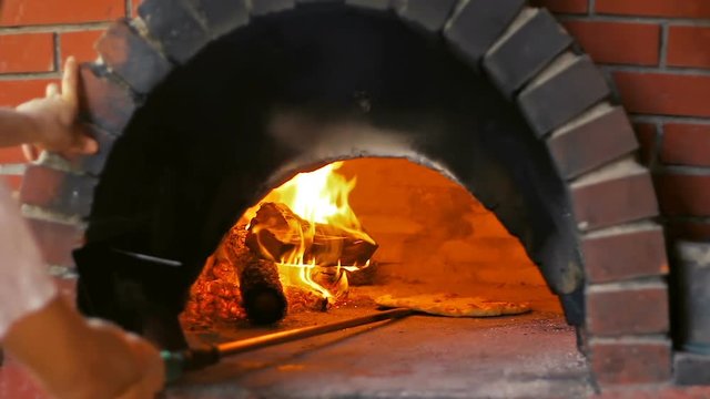 Chef Baking Pizza In Wood Fired Oven
