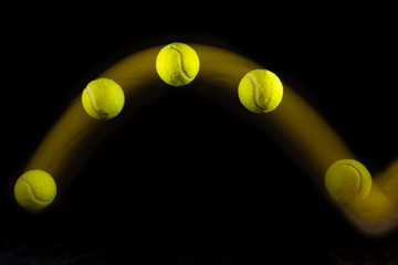 Movement or bounce of tennis ball isolated on black background.