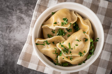 Traditional pelmeni, ravioli, dumplings with meat, close-up, copy space, top view.