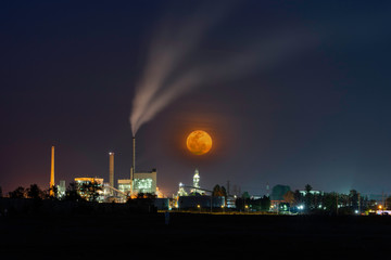 Naklejka na ściany i meble Big moon and Huge power plant with many lights at night