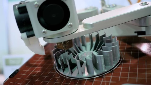 3D printer machine printing plastic workpiece look like metal at futuristic technology exhibition - close up shot. Additive technologies, 4.0 industrial revolution and manufacturing concept