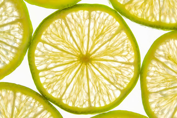 Fresh lemon fruit slices illuminated on white background