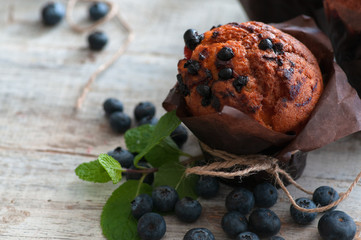 maffin with blueberries and various forest fruits, raspberries, strawberries. There are different types of wood on the table.