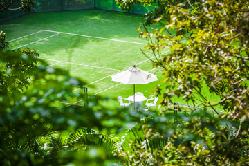 tennis court with table and umbrella in the tropics