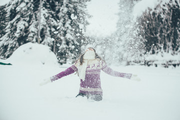 Amazing young woman plays with snow