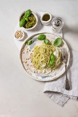 Classic italian spaghetti pasta with pesto sauce, pine nuts, olive oil and fresh basil. Served in...