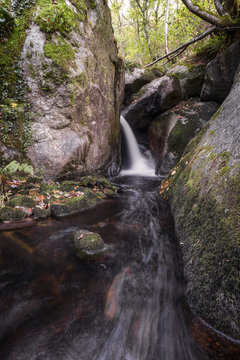 A stream forms a water jet between granitic rocks