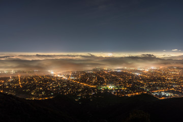 Fototapeta premium Night fog view of Pasadena and Los Angeles from peak in the San Gabriel Mountains. 