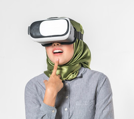 Veiled teenager wearing virtual reality box with white background.