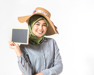 Veiled teenager holding black board with white background.