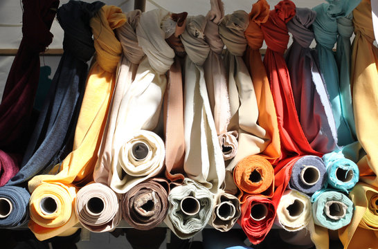 Multicolored rolls of fabrics and textiles on the market. Sale of textiles on the Turkish market in Berlin
