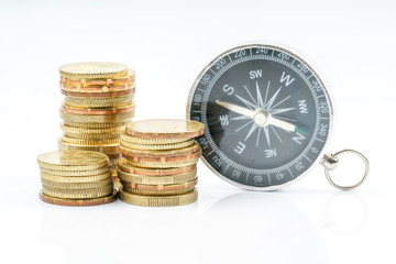 Coins and compass with white background. Financial concept.