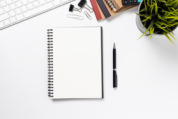 Top view, empty notebook and office supplies on the desk.