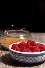 Bowl of raspberries on wooden background