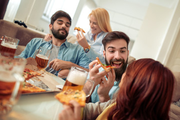 Group of happy young people eating pizza