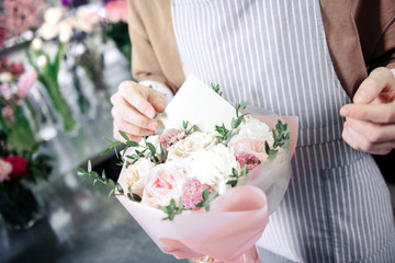 Enigmatical professional florist creating bouquet for girlfriend