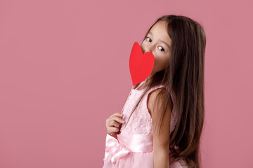cute little girl in a pink dress holding a paper heart