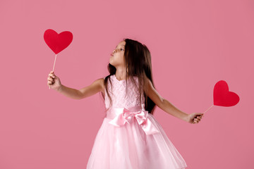 cute little girl in a pink dress holding a paper heart