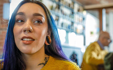 Modern blue violet hair woman with piercings and tattoos portrait.Group of multiethnic people...