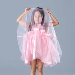 Fototapeta na wymiar cute little girl in pink princess dress on gray background.