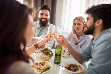 Group of friends enjoying meal at home together