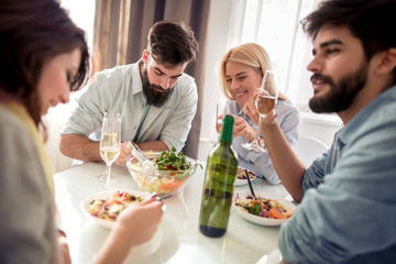 Group of friends enjoying meal at home together