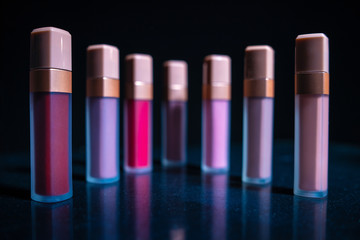 Obraz premium Lipstick. Fashion Colorful Lipsticks over black background. Lipstick tints palette. Beautiful Make-up concept.