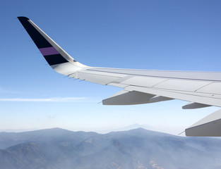Fototapeta na wymiar Wing of airplane flying over Mexican mountains